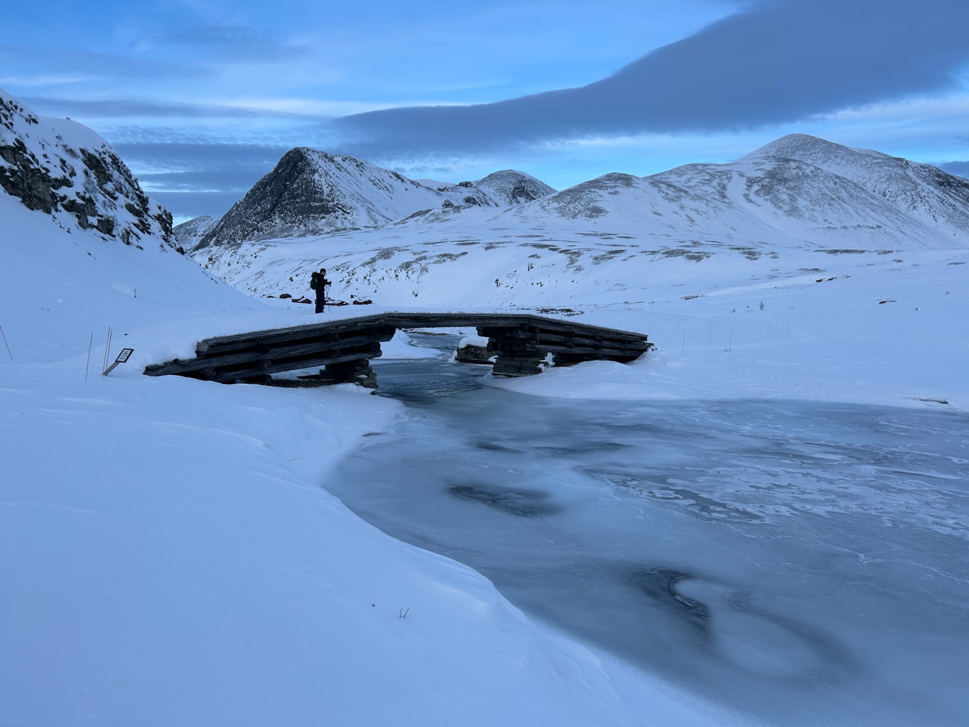 Over broen og hen til hytten, der kan anes i baggrund